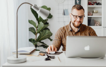 Man sitting at desk with laptop explaining bi me and business insurance